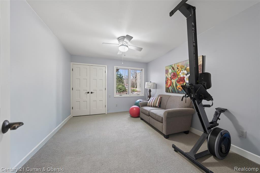 Workout area featuring light carpet and ceiling fan