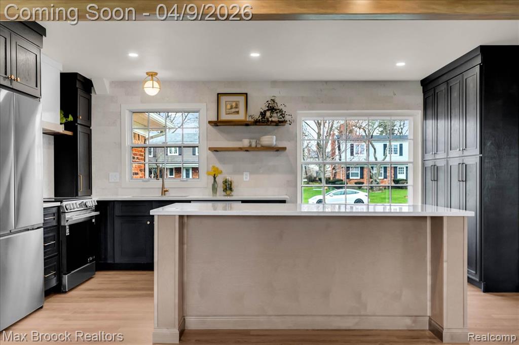 Kitchen with a kitchen island, open shelves, stainless steel appliances, light wood-type flooring, and recessed lighting