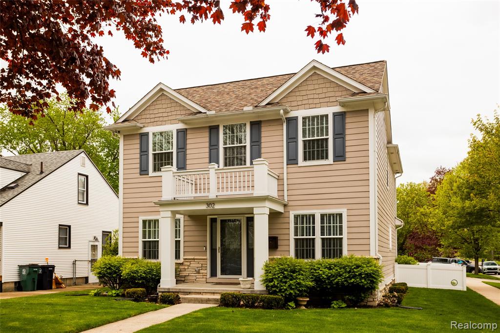 View of front of home with a balcony and roof with shingles