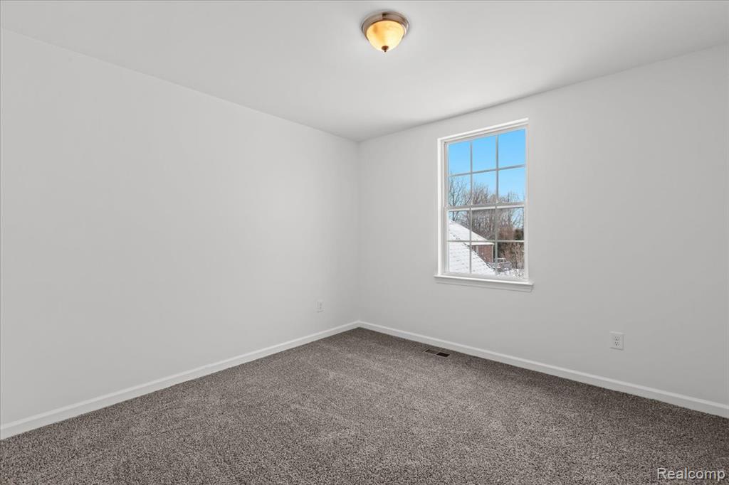 Finished below grade area featuring dark wood-type flooring and baseboards