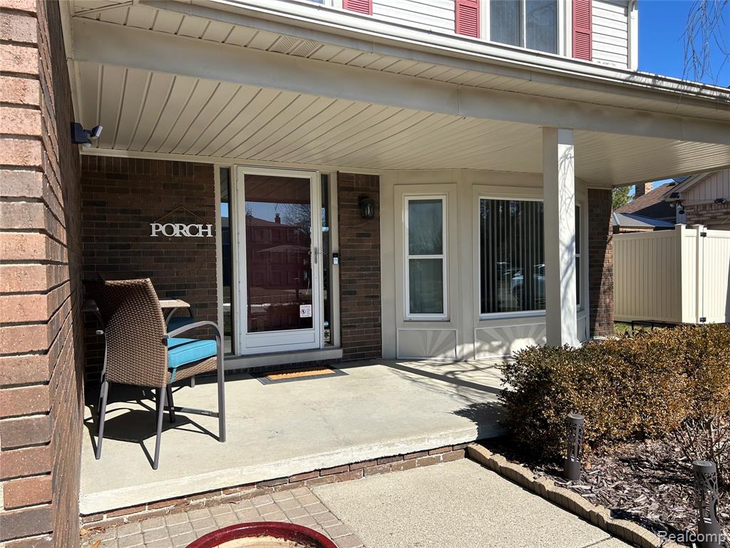 Doorway to property with brick siding and a porch