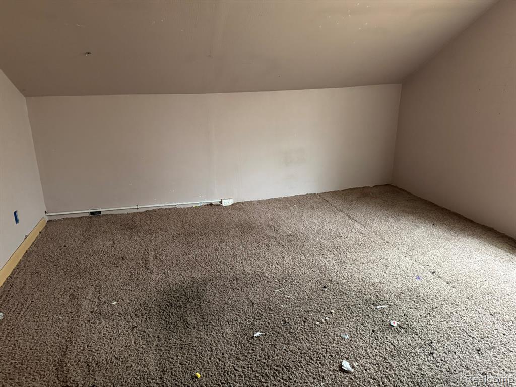 Bonus room with vaulted ceiling and carpet flooring
