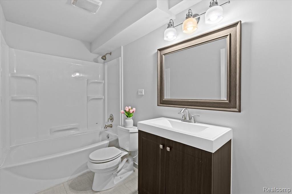 Snow covered rear of property with a patio area, brick siding, and entry steps