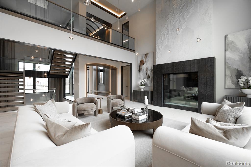Living room featuring a premium fireplace, a towering ceiling, and arched walkways