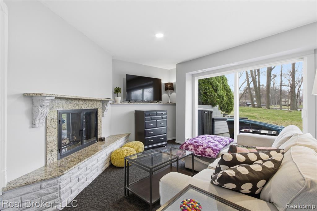 Living area with a premium fireplace and carpet