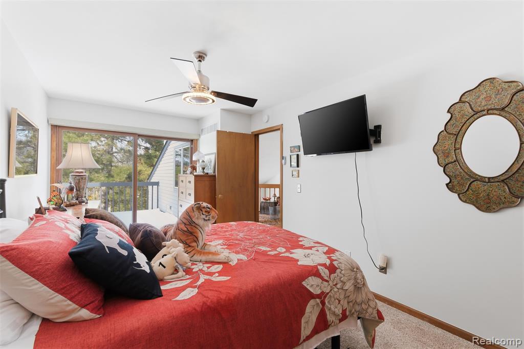 Bedroom featuring access to exterior, carpet flooring, and ceiling fan