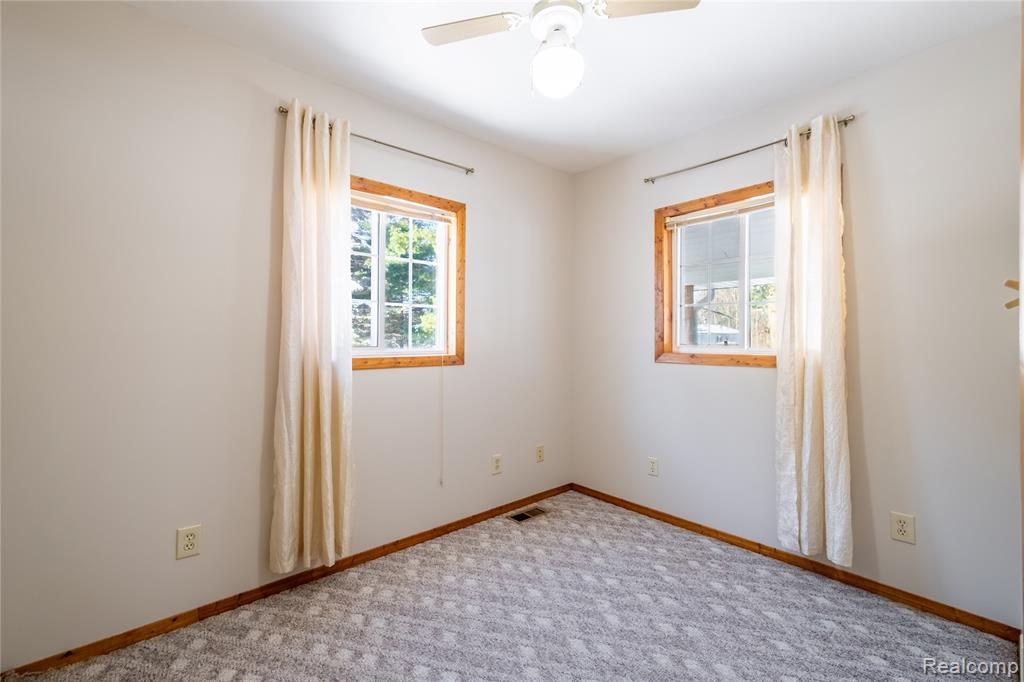 Empty room featuring carpet floors and ceiling fan