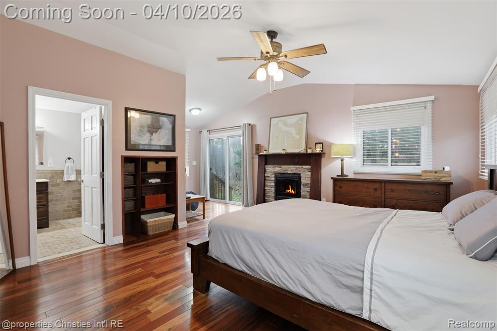 Primary features vaulted ceiling, stone electric fireplace and cozy sitting room.