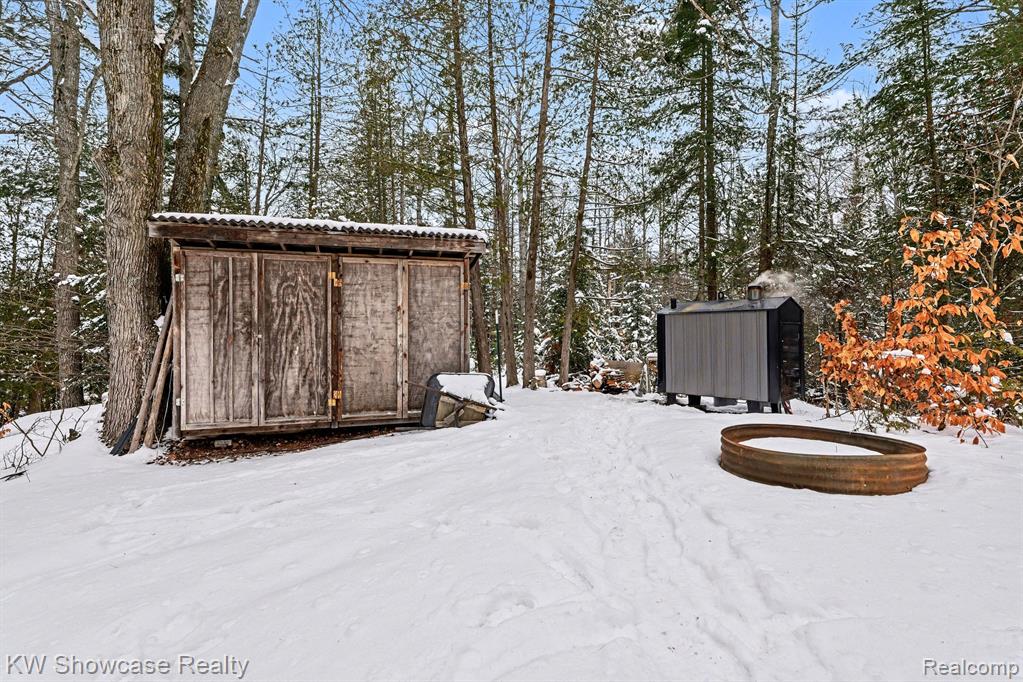 Snow covered structure featuring a storage shed