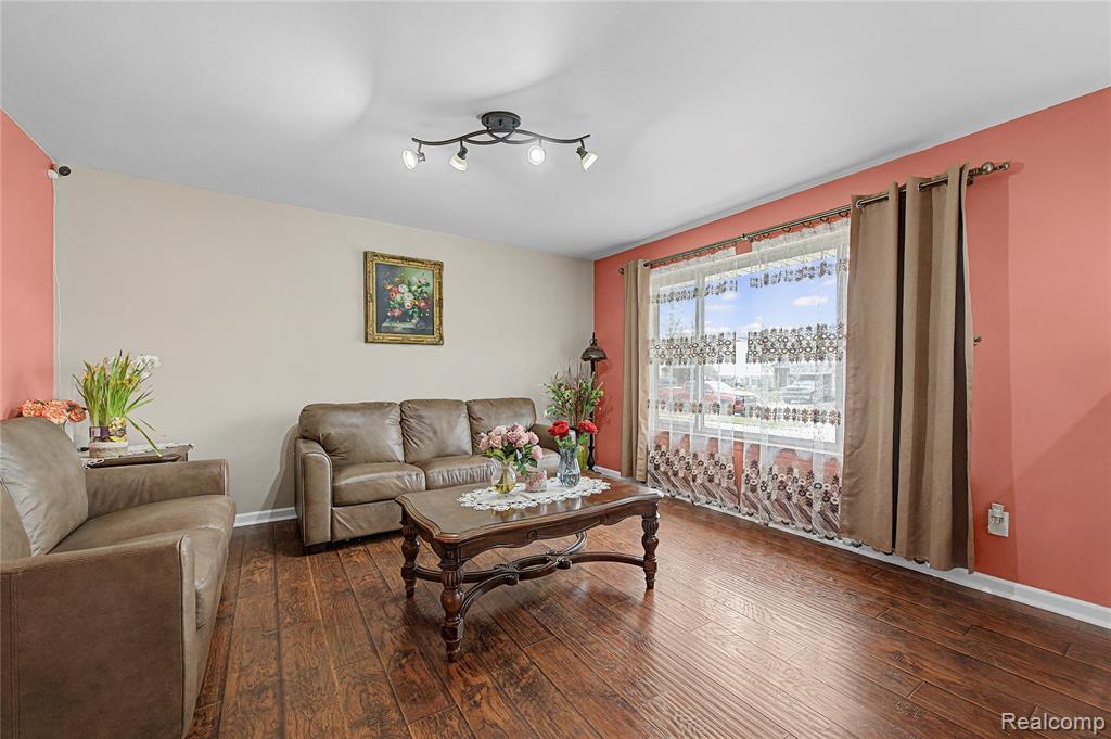 Living room featuring dark wood-type flooring and baseboards