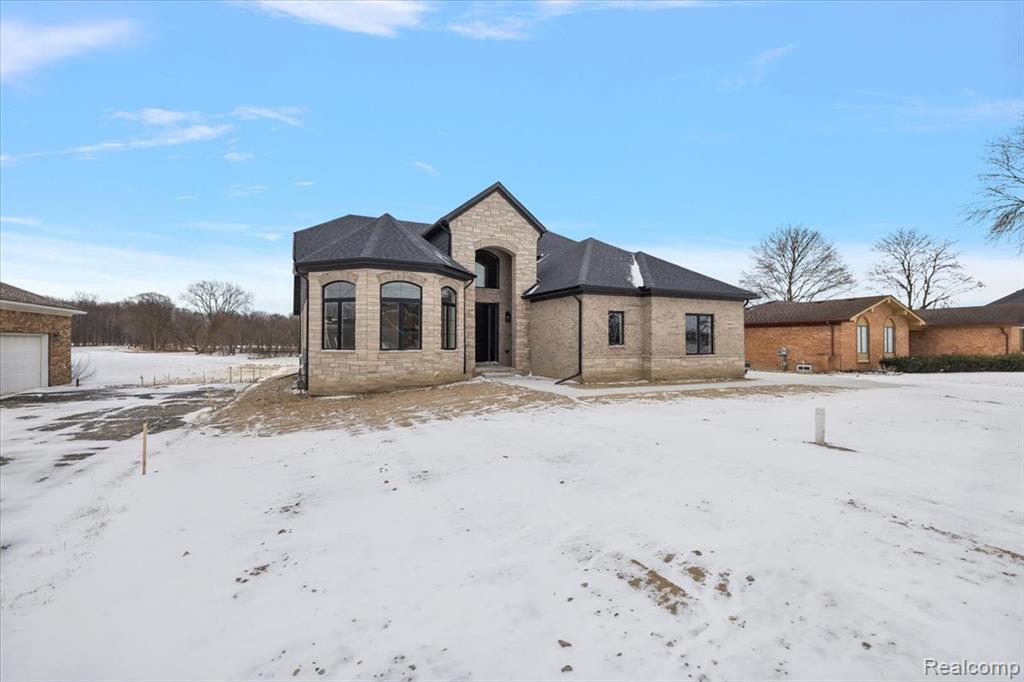 French provincial home with stone siding and brick siding