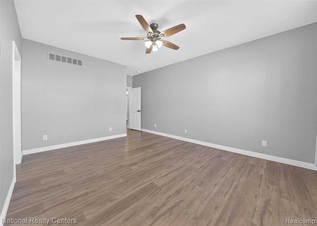 Unfurnished room featuring a ceiling fan and wood finished floors