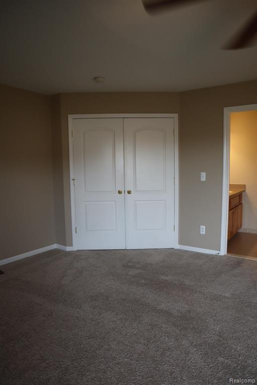 Unfurnished living room with light carpet and a ceiling fan