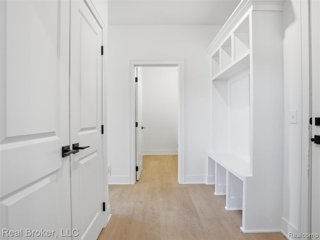 Mudroom with light wood-type flooring and baseboards