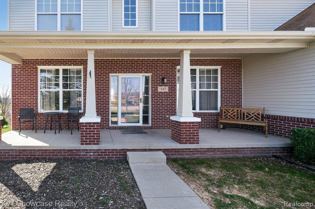 Entrance to property featuring covered porch and brick siding