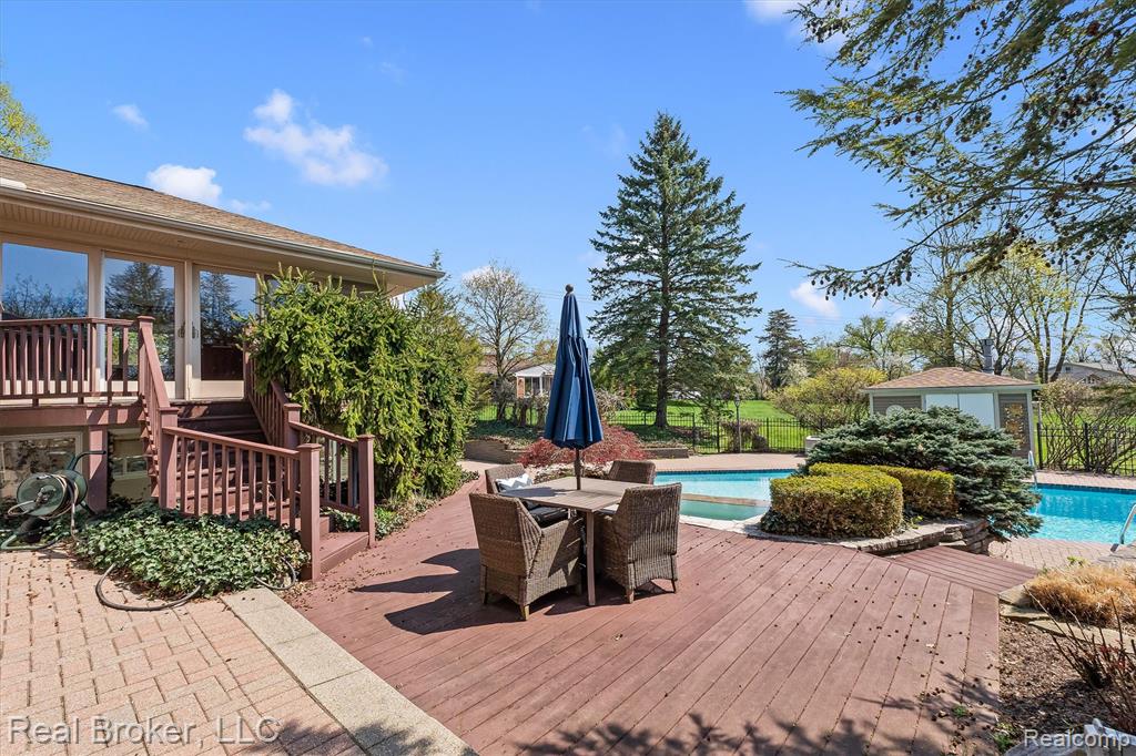 Deck with an outdoor pool and outdoor dining space