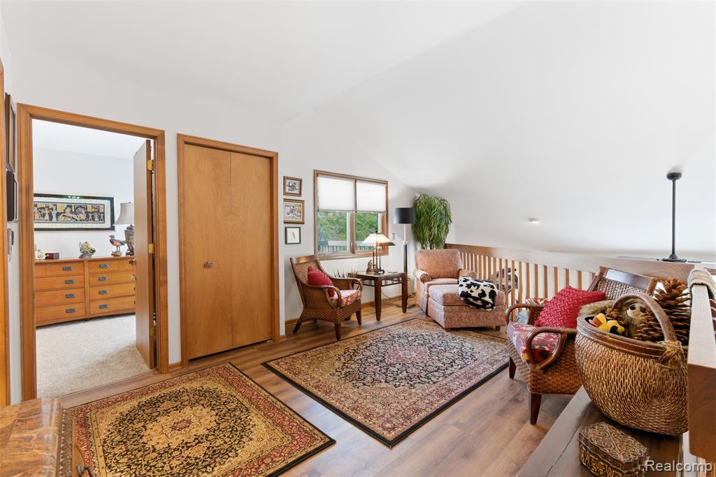 Sitting room with lofted ceiling and light wood-style floors