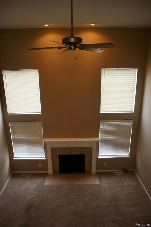 Unfurnished living room with a high ceiling and recessed lighting