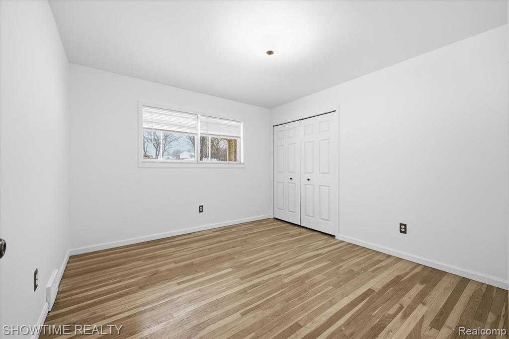 Unfurnished bedroom with light wood finished floors and a closet