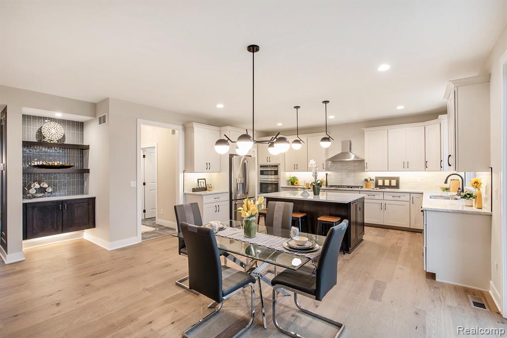 Dining room with light wood finished floors and recessed lighting