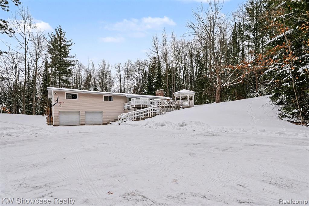View of snow covered exterior with a deck and a chimney