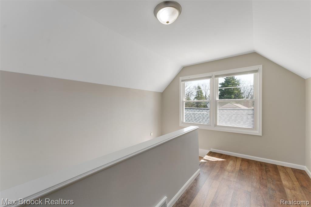 Hallway with light wood-style flooring and baseboards leads to upstairs bedroom
