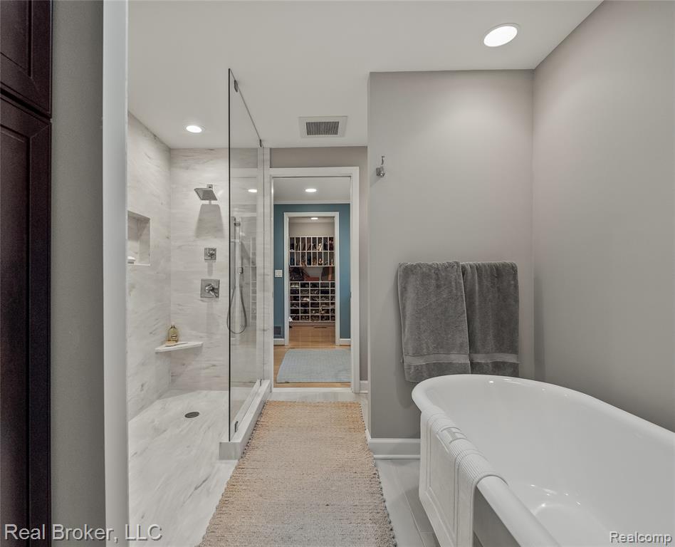 Full bathroom with a freestanding tub, a shower stall, and recessed lighting