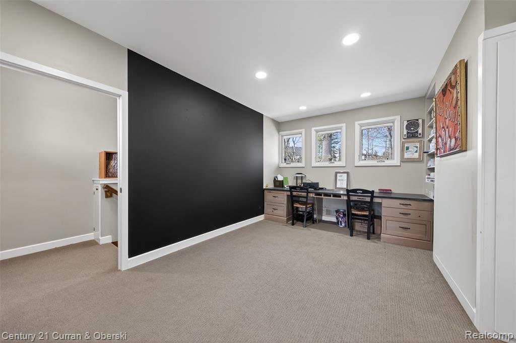 Office with light colored carpet and recessed lighting