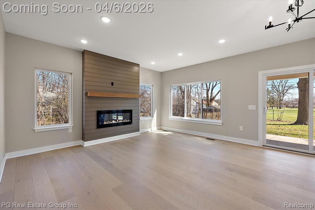 Unfurnished living room featuring a fireplace, light wood-type flooring, and recessed lighting