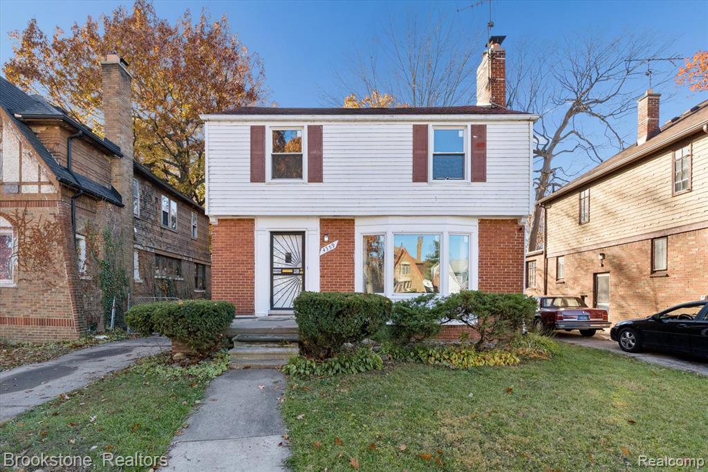 Photo for 4359 Courville Street, Detroit, MI 48224 - listing #20251054197 Colonial-style house featuring a front lawn, brick siding, and a chimney