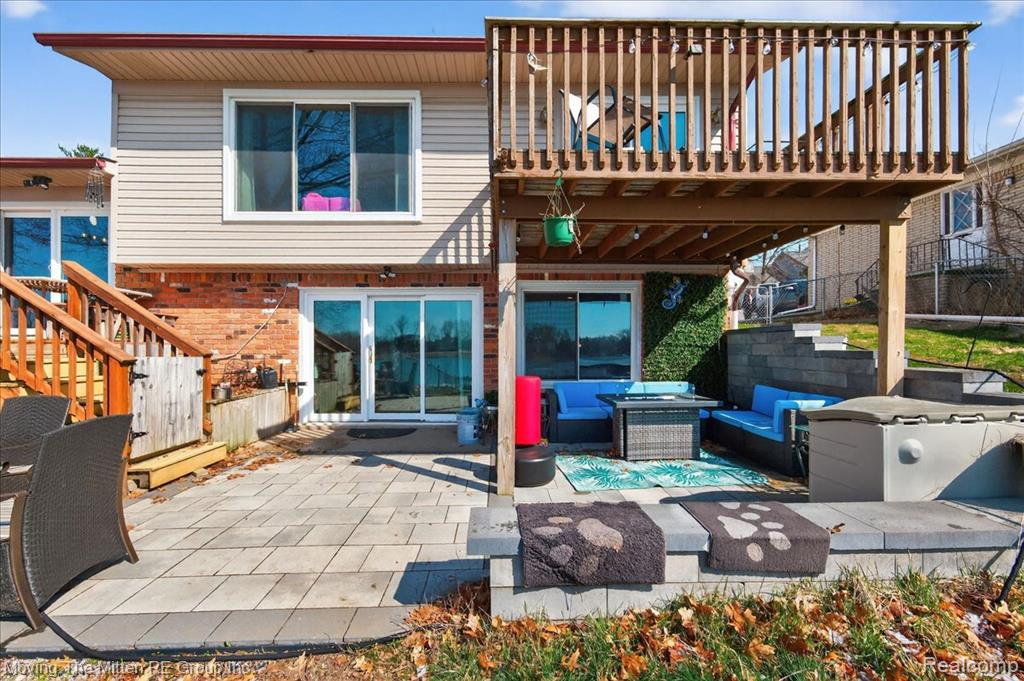 Back of house featuring a patio, outdoor furniture, a balcony, a pergola, and brick siding
