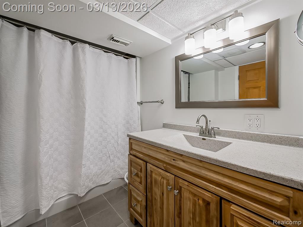 Laundry area with washing machine and clothes dryer, electric water heater, light wood finished floors, and heating unit