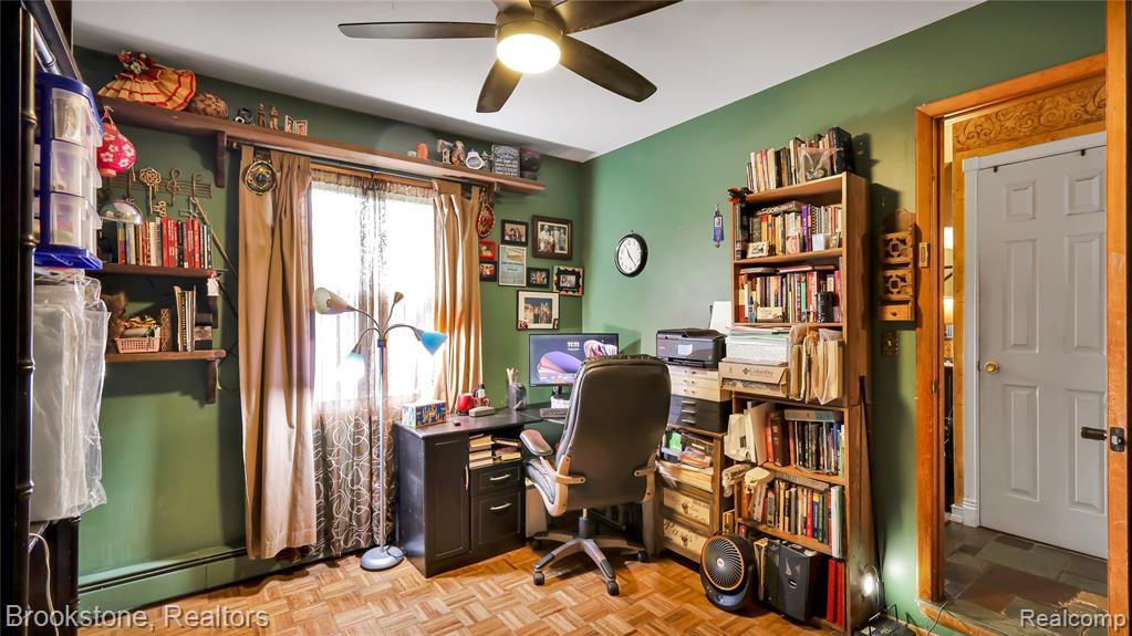 Office with parquet floors, a ceiling fan, and baseboard heating