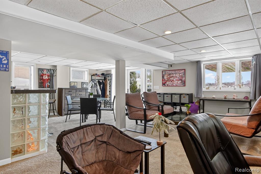 Living room with a drop ceiling and carpet flooring