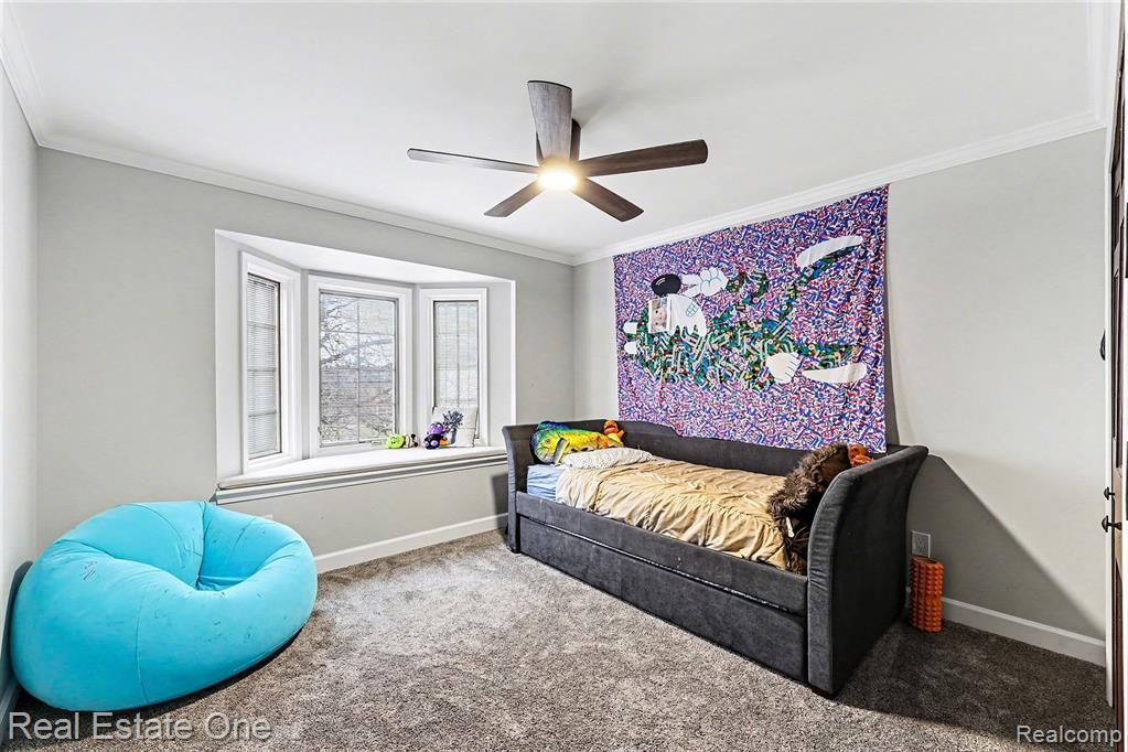 Bedroom featuring carpet flooring, crown molding, and ceiling fan