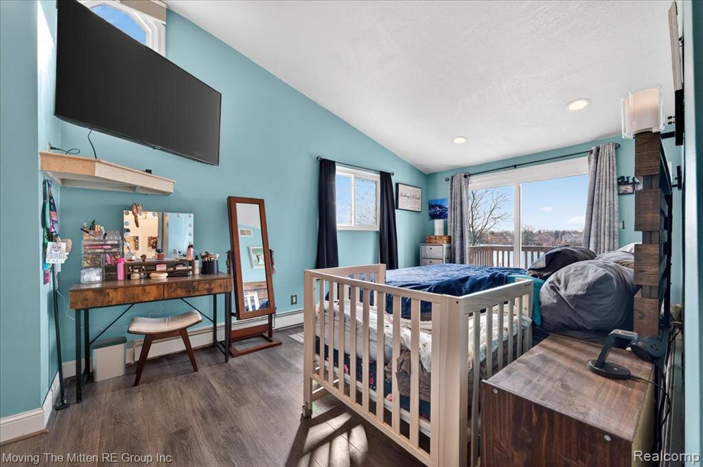 Bedroom featuring lofted ceiling, dark wood-style floors, access to outside, and recessed lighting