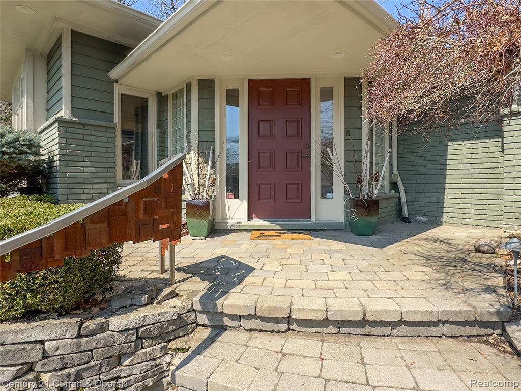 Property entrance with a porch and brick siding