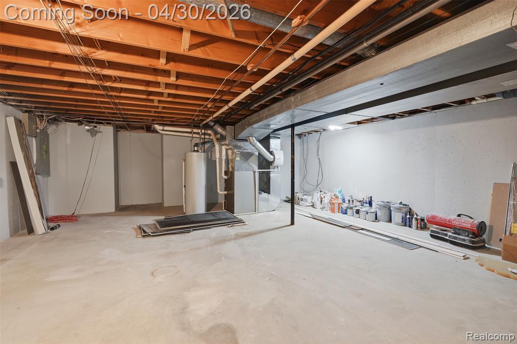OODLES OF STORAGE! Unfinished basement featuring heating unit, new gas water heater, and electric panel