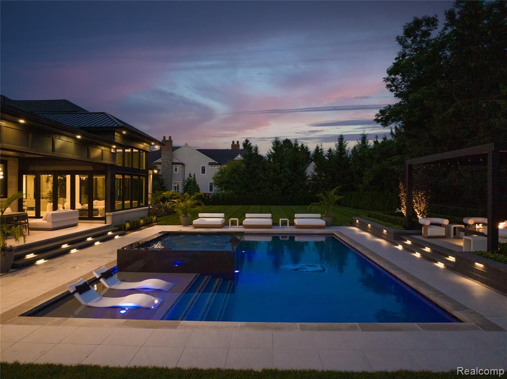 Pool at dusk featuring a patio, outdoor lounge area, and an outdoor pool