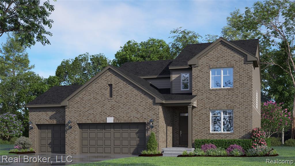Traditional home featuring an attached garage, brick siding, concrete driveway, and a front lawn
