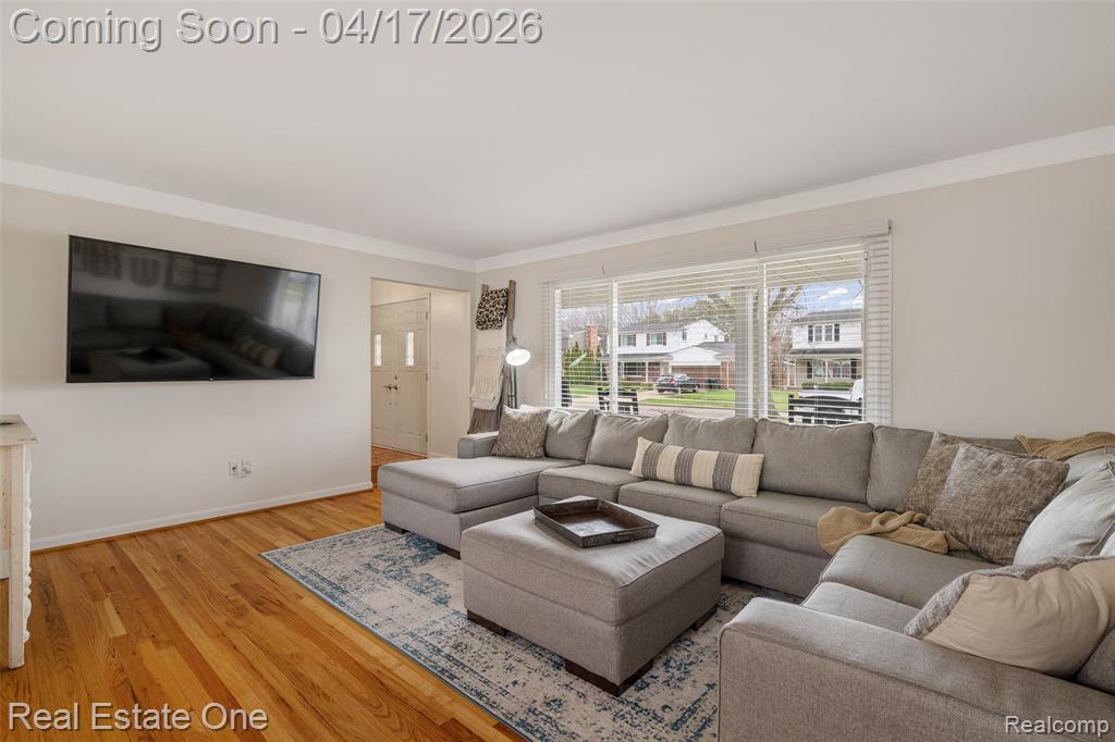 Living area featuring light wood-style floors and ornamental molding
