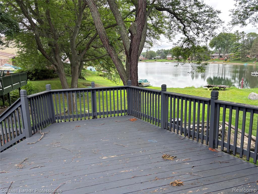 Deck with a water view and a yard